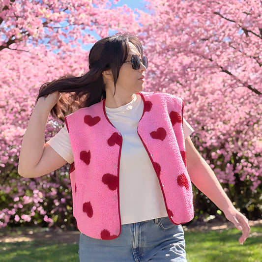 gilet sans manche rose et rouge avec petits cœurs porté sur un mannequin en extérieur 