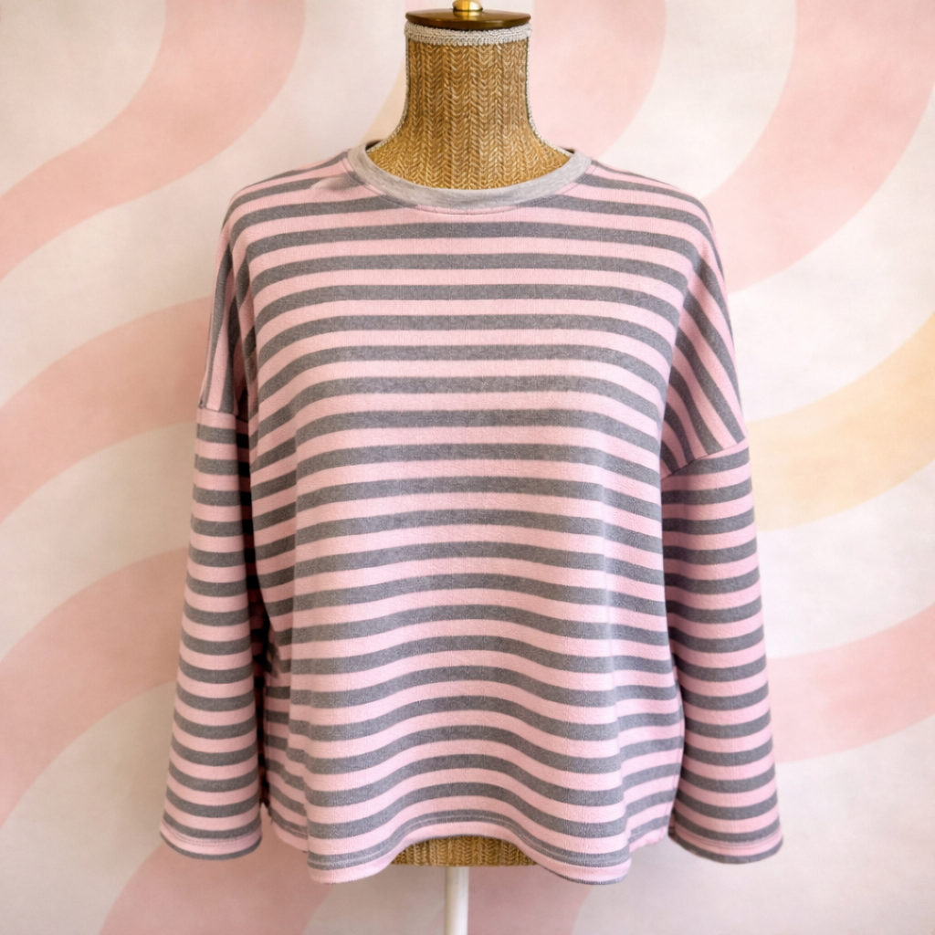 marinière rayure rose et gris portée sur un buste 