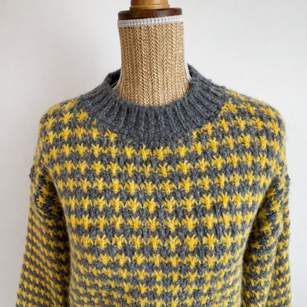 zoom sur le col du pull a carreaux gris et jaune 