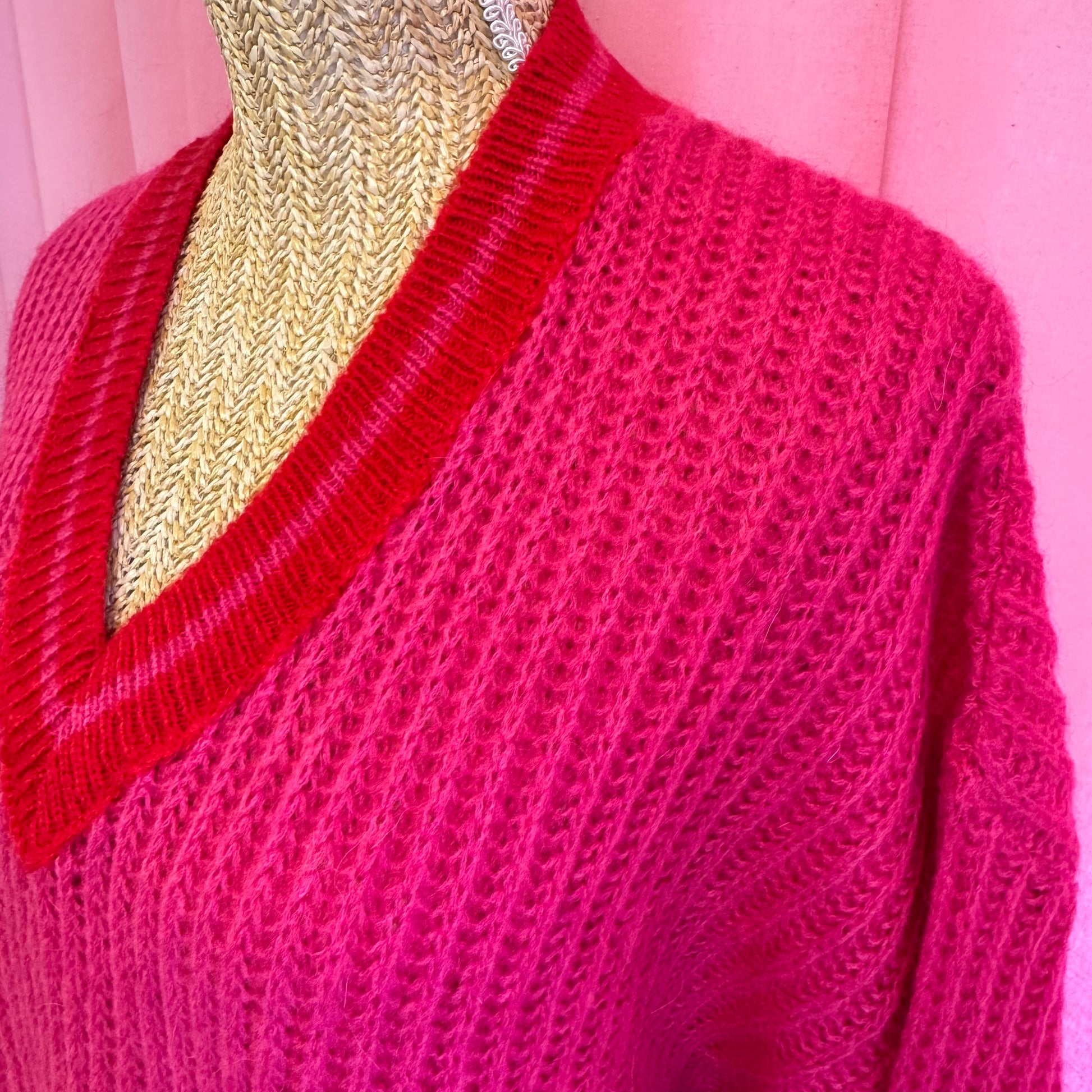 détail du pull rose col V rouge